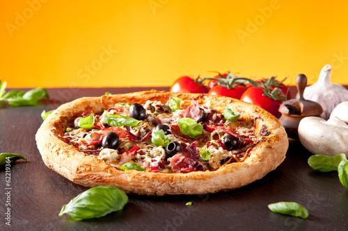 Board z aluminiowym obramowaniem Świeża włoska pizza podawana na czarnym kamieniu