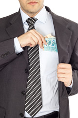 Wall Mural - A businessman in a suit putting brazilian money in his pocket