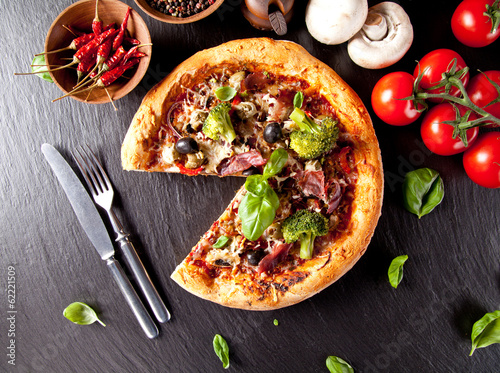 Board z aluminiowym obramowaniem Świeża włoska pizza podawana na czarnym kamieniu
