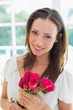 © lightwavemedia - Beautiful young woman with flowers at home