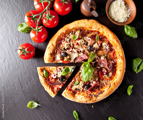Board z aluminiowym obramowaniem Świeża włoska pizza podawana na czarnym kamieniu