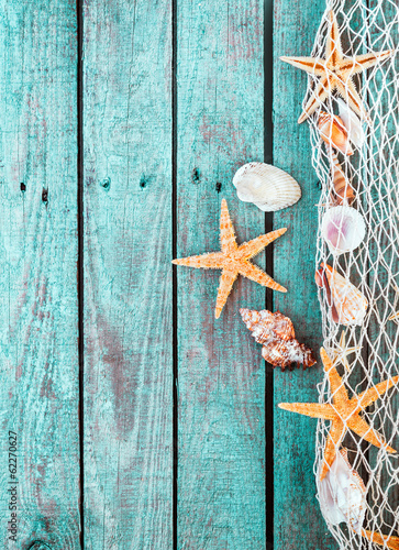Naklejka na drzwi Seesterne Meerestiere im Fischernetz auf alt Holz Hintergrund