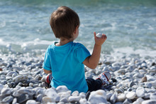 Boy Throwing Stones In The Sea