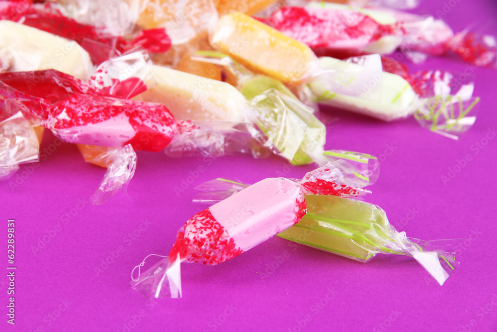 Tasty candies on purple background