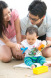 © wong yu liang - asian baby playing sand on the beach with father and mother