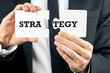 © Gajus - Man holding two pieces of a puzzle with Strategy