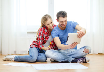 Canvas Print - smiling couple looking at tablet pc at home