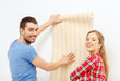 © Syda Productions - smiling couple choosing wallpaper for new home