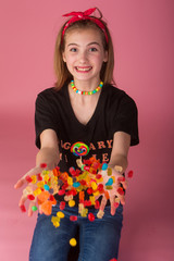 Wall Mural - Young girl with a handful of colorful candy