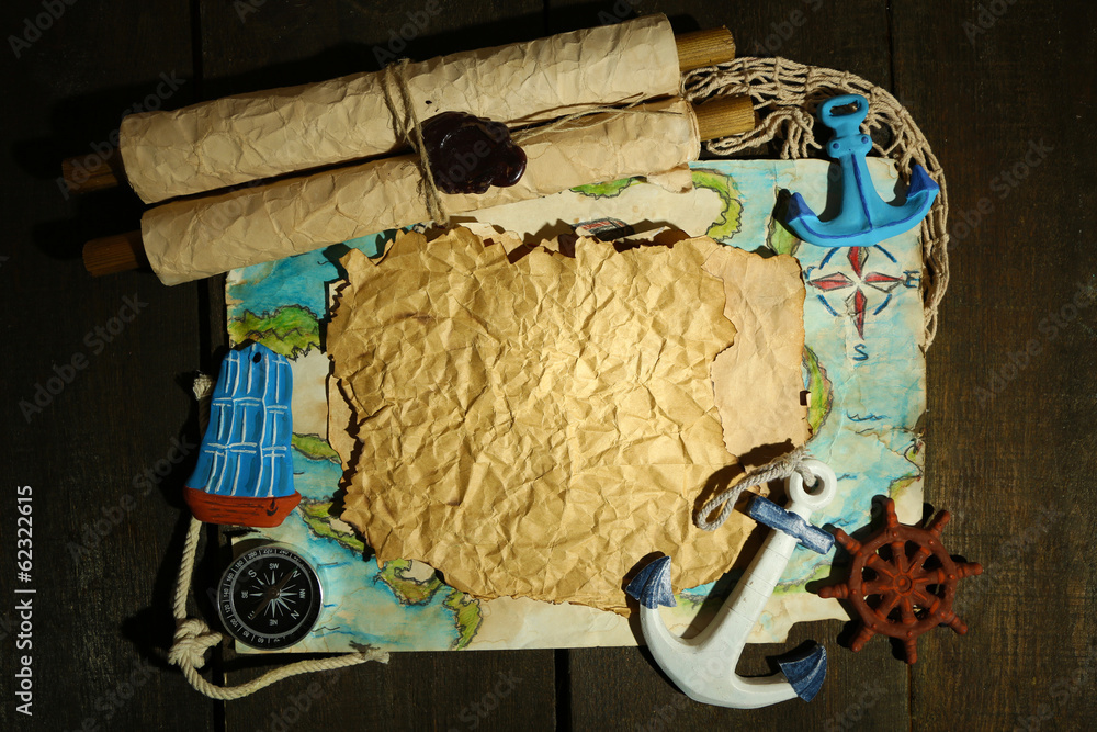 Old paper with sea accessories, isolated on wooden background