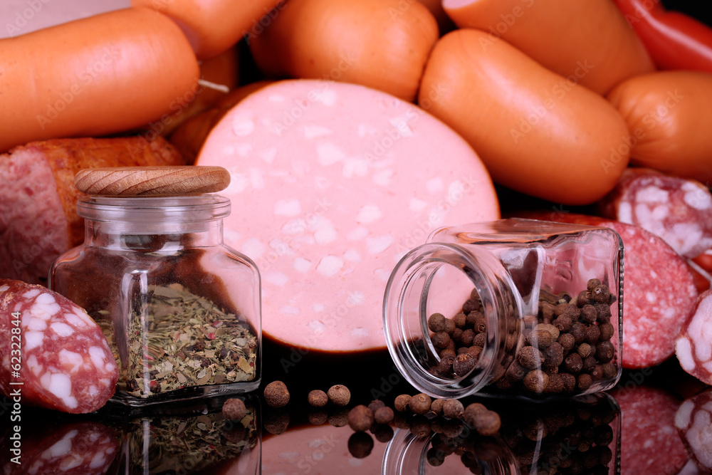 Lot of different sausages with spices on black background