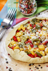 Poster - Vegetable galette on wooden kitchen board before baking.