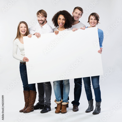 Fotografía Lachende Junge Leute zeigen weißes Plakat
