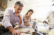 © Monkey Business - Two Architects Making Models In Office Using Digital Tablet