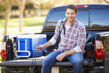 Man Sitting In Pick Up Truck On Camping Holiday