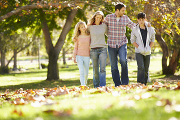 Wall Mural - Family Walking Through Autumn Woodland