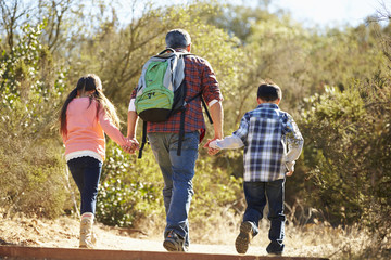 Wall Mural - Rear View Of Father And Children Hiking In Countryside