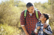 © Monkey Business - Father And Son Hiking In Countryside Wearing Backpacks