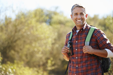 Wall Mural - Portrait Of Man Hiking In Countryside Wearing Backpack