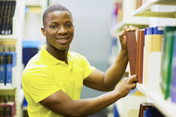 Wall Mural - african american college boy pulling library book