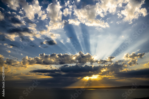 Fotoboard na płycie Promienie słońca o zachodzie słońca z chmurami światła śledzenia sunbeams.