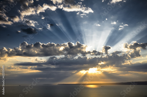 Fotoboard na płycie Promienie słońca o zachodzie słońca z chmurami światła śledzenia sunbeams.