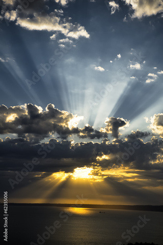 Fotoboard na płycie Promienie słońca o zachodzie słońca z chmurami światła śledzenia sunbeams.