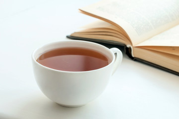 Cup of black tea and some books to read lying on the table