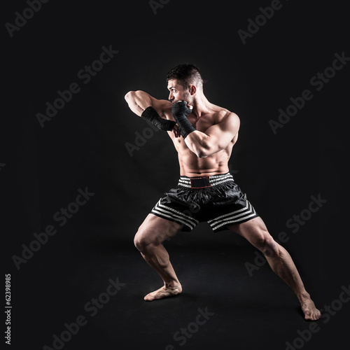 Obraz na płótnie canvas czteroczęściowy "tetraptyk" Sportowiec kick boxer pełny portret ciała na czarnym tle