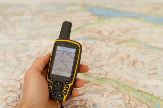 Fototapete -  - Hand held outdoor GPS and a map.