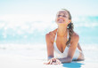 © Alliance - Relaxed young woman laying at seaside