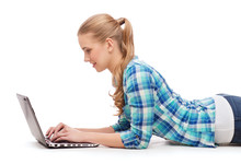 Smiling Woman With Laptop Computer Lying On Floor