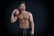 © theartofphoto - Muscular american football player standing with ball