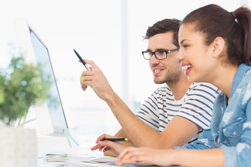 Wall Mural - Happy young couple working on computer in an office