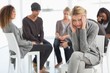 © WavebreakMediaMicro - Upset woman with head in hands at rehab group looking at camera