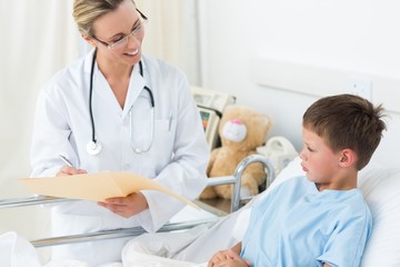 Wall Mural - Doctor examining report of sick boy