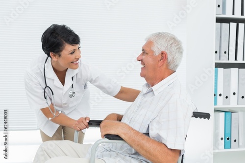 Fotografía Female doctor talking to senior patient in wheelchair