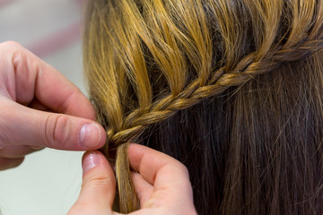 Hairdresser makes braids