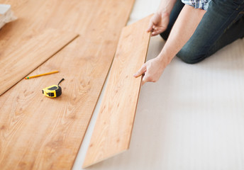 close up of male hands intalling wood flooring