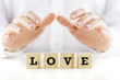 © Gajus - Man holding protective hands above the word Love