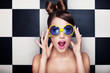 Leinwandbild Motiv Attractive surprised young woman wearing sunglasses
