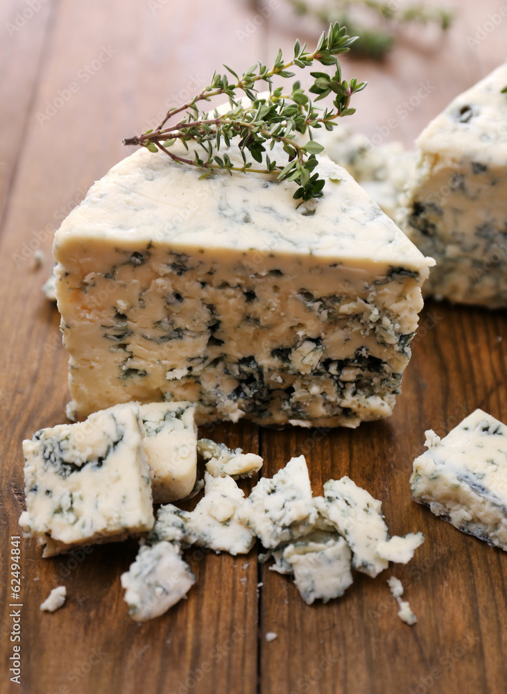 Tasty blue cheese with thyme, on wooden table