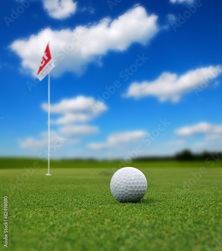 Obraz na płótnie canvas trzyczęściowy "tryptyk" Piłeczka golfowa przed flagą