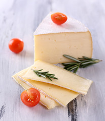 Wall Mural - Tasty Camembert cheese with tomato and rosemary, on wooden