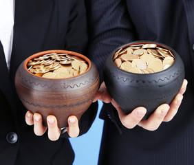 Sticker - Two ceramic pots with golden coins in male and female hands,