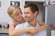 © lightwavemedia - Woman embracing man from behind in kitchen