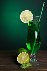 Poster - Glass of cocktail on table on dark green background