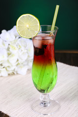 Poster - Glass of cocktail on table on dark green background