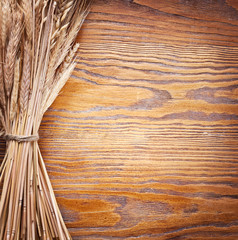 Canvas Print - Ears of wheat on old wooden table.