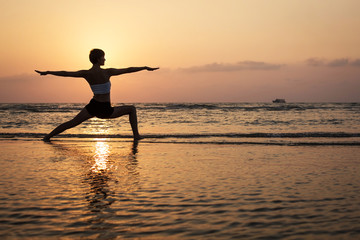 Yoga silhouette on the beach, virabhadrasana